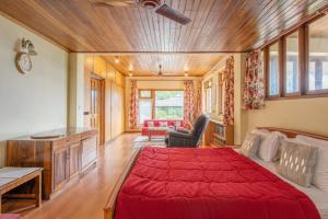 - une chambre avec un grand lit rouge dans l'établissement La Ipsing Farm by StayVista, A heritage property in orchards with Mountain views, featuring Outdoor games and A cozy balcony for a memorable stay, à Samdong
