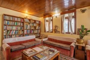 a living room with two couches and bookshelves at La Ipsing Farm by StayVista, A heritage property in orchards with Mountain views, featuring Outdoor games and A cozy balcony for a memorable stay in Samdong