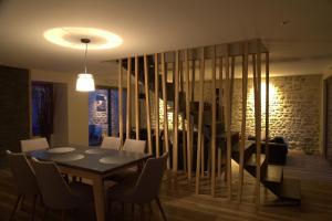 a dining room with a table and a spiral staircase at Le Clos Des Coteaux in Trigny