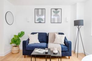 a living room with a blue couch and a table at Soho & Fitzrovia with Balcony - CityApartmentStay in London