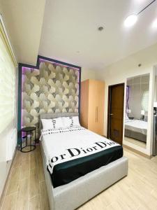 um quarto com uma cama grande e uma cabeceira. em Lafayette Park Square Megaworld em Iloilo