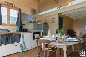 eine Küche mit einem Tisch mit Stühlen und eine Küche mit einem Tisch in der Unterkunft Gîte cabane insolite Pyrénées in Sauveterre