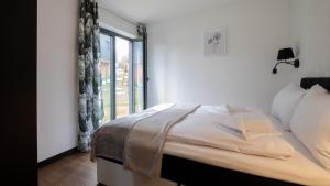 a bedroom with a bed and a large window at Apartamenty Sun & Snow Enklawa pod Bieniatką in Szczyrk