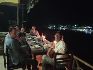 a group of people sitting at a table at night at VangVieng Ruby'Homestay in Vang Vieng