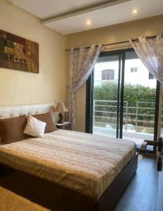 a bedroom with a large bed and a large window at Pied sur mer "Un paradis à bas prix" in Tamaris