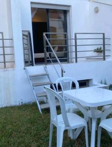 un tavolo bianco e sedie su un patio di Pied sur mer 'résidence galets sur mer' a Tamaris