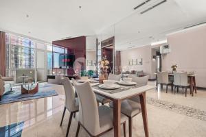 a dining room and living room with a table and chairs at Soka by Kozystay - Mega Kuningan in Jakarta