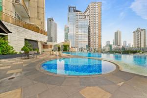 a swimming pool in the middle of a city with tall buildings at Soka by Kozystay - Mega Kuningan in Jakarta