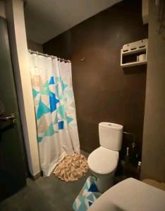 a bathroom with a toilet and a shower curtain at Pied sur mer "Un paradis à bas prix" in Tamaris +2 photos