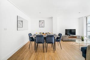 a white living room with a table and chairs at Heart of Holborn with Patio - CityApartmentStay in London