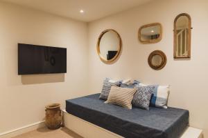 Schlafzimmer mit einem Flachbild-TV an der Wand in der Unterkunft Buckingham Mews _ Rockpool Cottage 5 in Kent