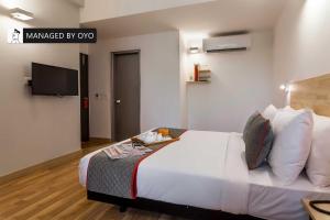 um quarto de hotel com uma cama e uma televisão em Townhouse Greater Kailash Near Kailash Colony Metro Station em Nova Deli