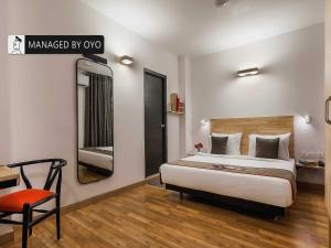 a hotel room with a bed and a sign that readsmanaged by ox at Townhouse Greater Kailash Near Kailash Colony Metro Station in New Delhi