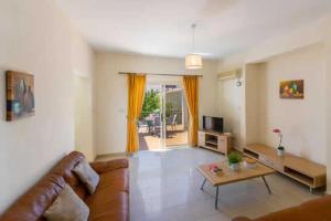 a living room with a couch and a table at Villa Corallia Dream 11 in Peyia