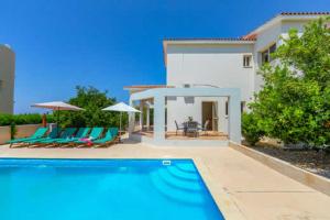 a swimming pool in front of a house at Villa Corallia Dream 11 in Peyia