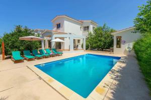 a swimming pool in front of a villa at Villa Corallia Dream 11 in Peyia