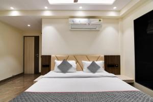 um quarto com uma grande cama branca com almofadas em Super Townhouse New Town near DLF 1 em Calcutá