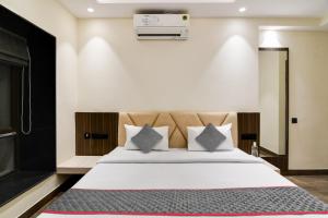 um quarto com uma cama com lençóis brancos e almofadas em Super Townhouse New Town near DLF 1 em Calcutá