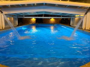 two people in a swimming pool with water being released at Hotel Don Diego in Suances