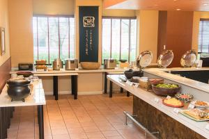 a large kitchen with tables with food on them at Chisun Hotel Hamamatsucho in Tokyo