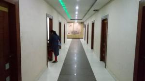 une femme marchant dans un couloir dans un bâtiment dans l'établissement Hotel Vinayak Palace Telipara, à Bilāspur