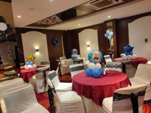 una stanza con due tavoli con sedie bianche e palloncini di Hotel Vinayak Palace Telipara a Bilaspur