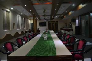 una sala conferenze con un lungo tavolo e sedie di Hotel Vinayak Palace Telipara a Bilaspur