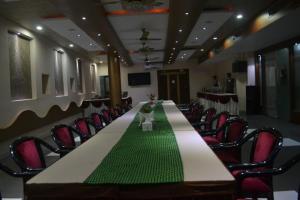 een vergaderzaal met een lange tafel en stoelen bij Hotel Vinayak Palace Telipara in Bilāspur