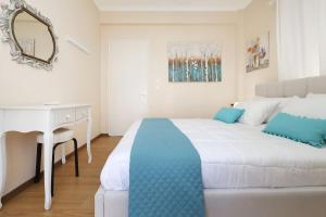 1 dormitorio con cama, escritorio y espejo en Areti's Home! en Agios Rokkos