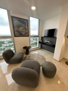 a living room with two chairs and a tv at Departamento chic Costanera Posadas in Posadas