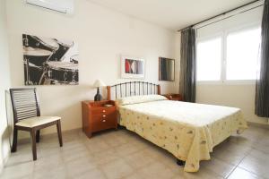 1 dormitorio con 1 cama, 1 silla y 1 ventana en AIGUESVERDS HomeStay By Turismar, en Reus