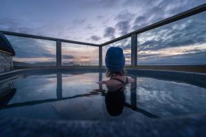 a little girl sitting in a pool watching the sunset at Midgard Base Camp in Hvolsv&ouml;llur