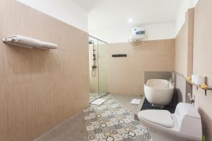 ein Badezimmer mit Toilette und Dusche in der Unterkunft Maja Villa Batubelig by Pramana Villas in Canggu