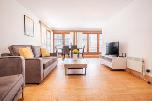 a living room with a couch and a tv at 2BR Penthouse with Terrace - Heart of Holborn - CityApartmentStay in London