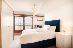 a bedroom with a large white bed and a window at 2BR Penthouse with Terrace - Heart of Holborn - CityApartmentStay in London