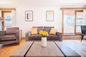 un soggiorno con divano e tavolo di 2BR Penthouse with Terrace - Heart of Holborn - CityApartmentStay a Londra