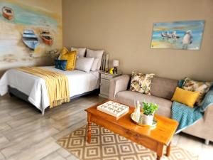 a living room with a bed and a couch at Bliss on JBay - Blissful in Jeffreys Bay
