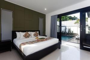 ein Schlafzimmer mit einem Bett und einem Pool in der Unterkunft Maja Villa Batubelig by Pramana Villas in Canggu + 18 Fotos