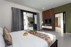 Ein Bett oder Betten in einem Zimmer der Unterkunft Maja Villa Batubelig by Pramana Villas