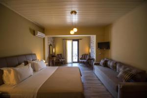 a bedroom with a large bed and a couch at Guesthouse Laoula in Gerolimenas