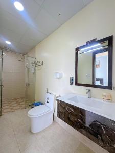 La salle de bains est pourvue d'une baignoire, de toilettes et d'un lavabo. dans l'établissement Apple Hotel, à Cần Thơ