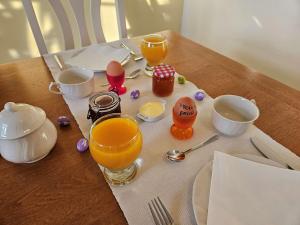 uma mesa com dois copos de sumo de laranja e ovos em B&B Pippa em Peer