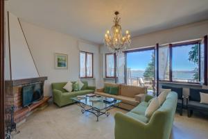 un soggiorno con divani, camino e lampadario pendente di Blooming Villa Cos Lake View - Happy Rentals a Belgirate