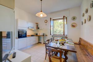 una cucina con tavolo e alcune sedie e tavolo e tavolo di Blooming Villa Cos Lake View - Happy Rentals a Belgirate