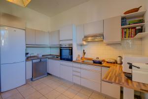 una cucina con mobili bianchi e un piano di lavoro in legno di Blooming Villa Cos Lake View - Happy Rentals a Belgirate