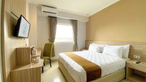 Ein Bett oder Betten in einem Zimmer der Unterkunft Lorin Syariah Solo Hotel