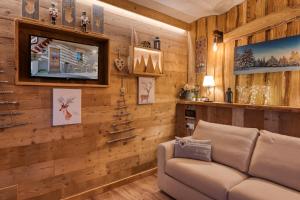 un soggiorno con pareti in legno e divano di LA ROCCIA - CASA VACANZA a Borgo San Dalmazzo