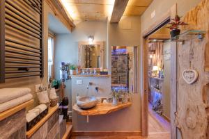 ein Badezimmer mit einem Waschbecken und einer Holztheke in der Unterkunft LA ROCCIA - CASA VACANZA in Borgo San Dalmazzo