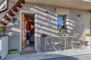 eine Terrasse mit einem Tisch und Stühlen neben einem Gebäude in der Unterkunft LA ROCCIA - CASA VACANZA in Borgo San Dalmazzo