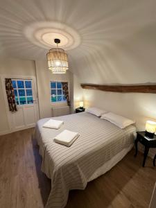 - une chambre avec un grand lit et 2 serviettes dans l'établissement Maisons de campagne au calme en Sologne pour groupe avec piscine - proche de Paris, à Brinon-sur-Sauldre